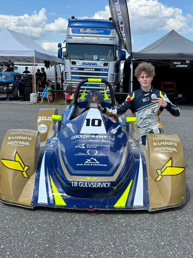 Mason ved sin Aquila Formula 1000 racerbil #10 med pokal